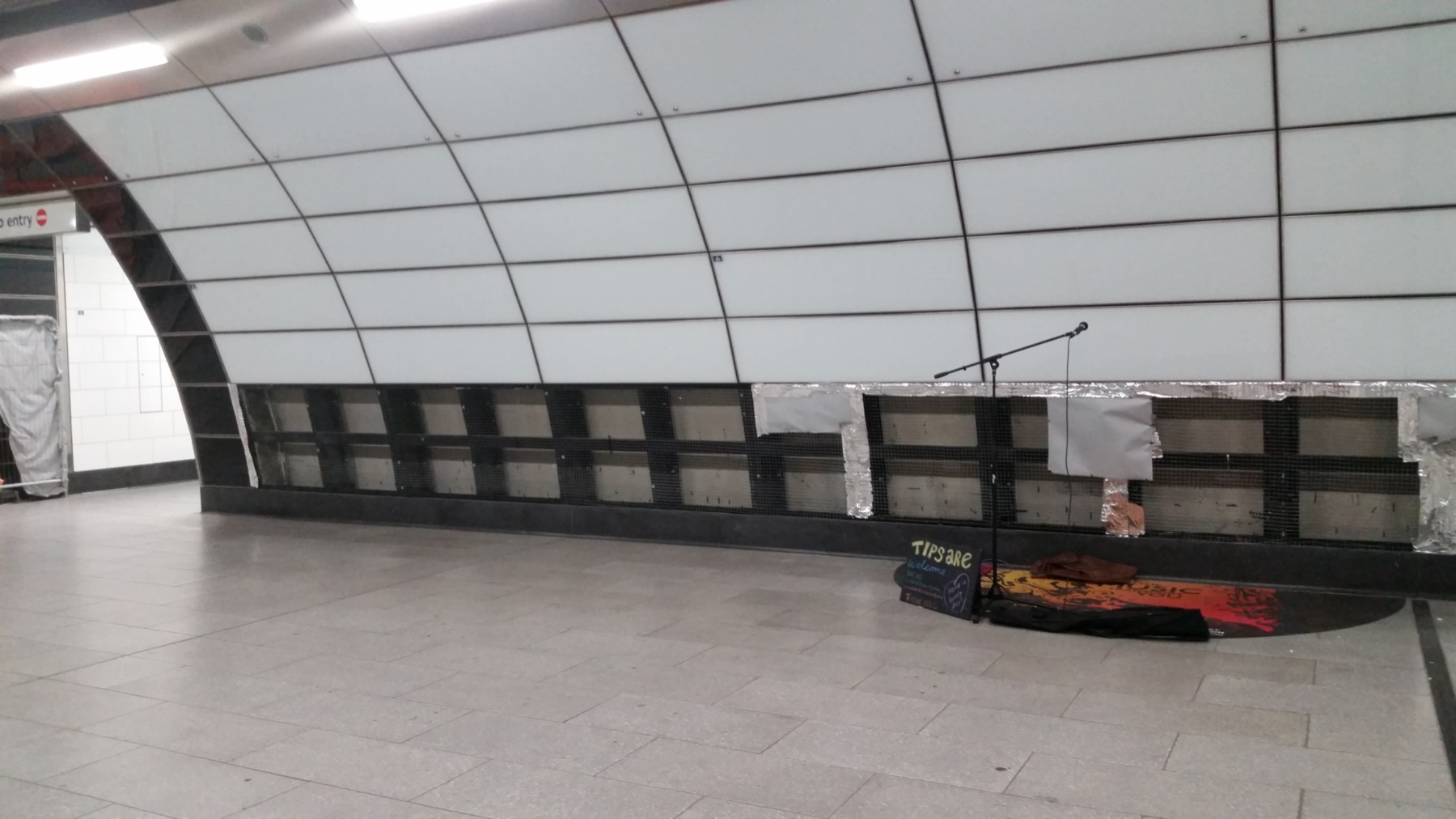 The pitch. It is flanked by an entrance to the Northern Line to the right, and an exit to the left. People leaving necessarily pass the pitch, but anybody going on won't pass the pitch unless they take a detour and disobey the signs.