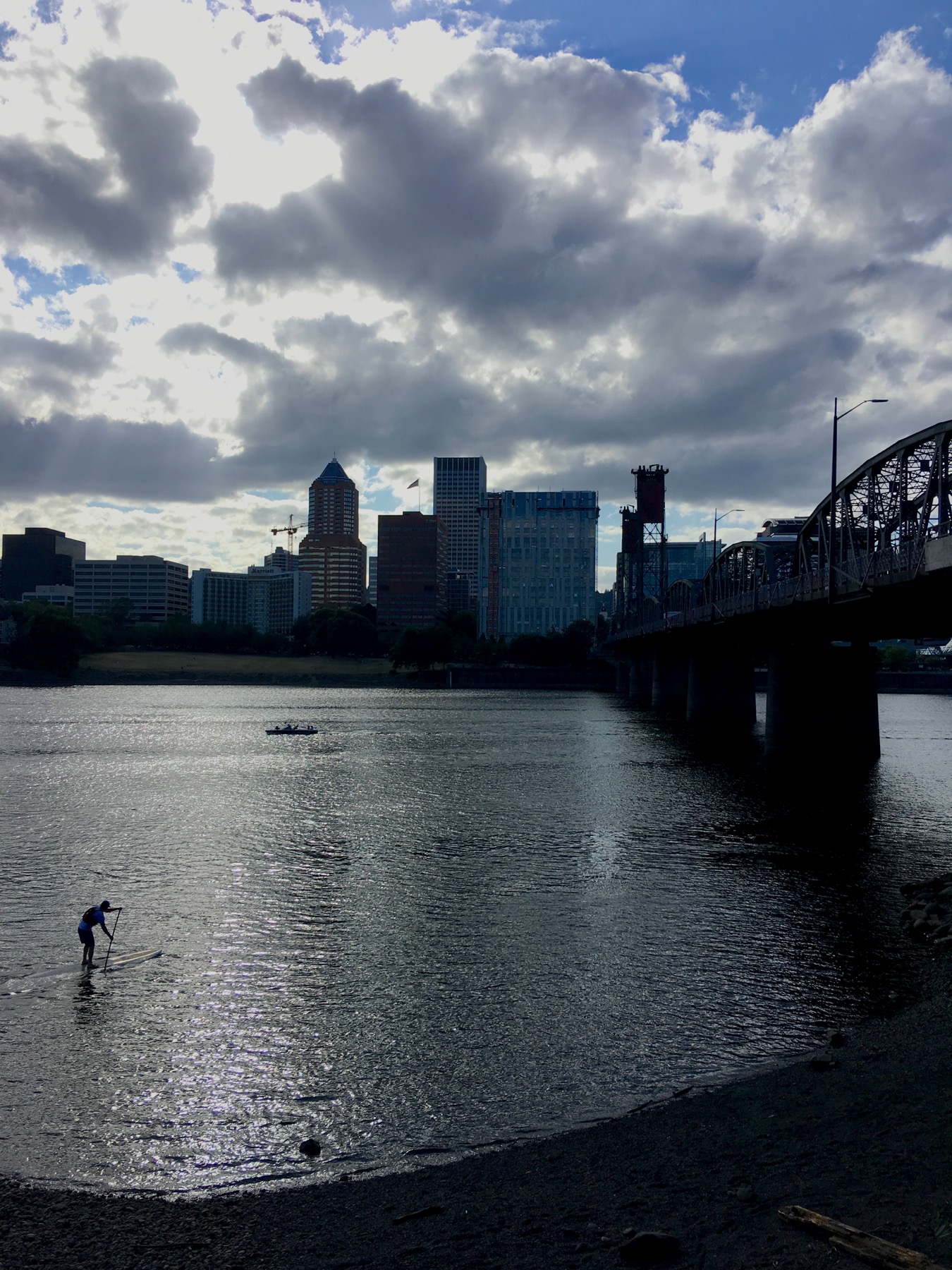 A lone paddleboarder heads underneath Hawthorne bridge in a rare moment of overcast weather.