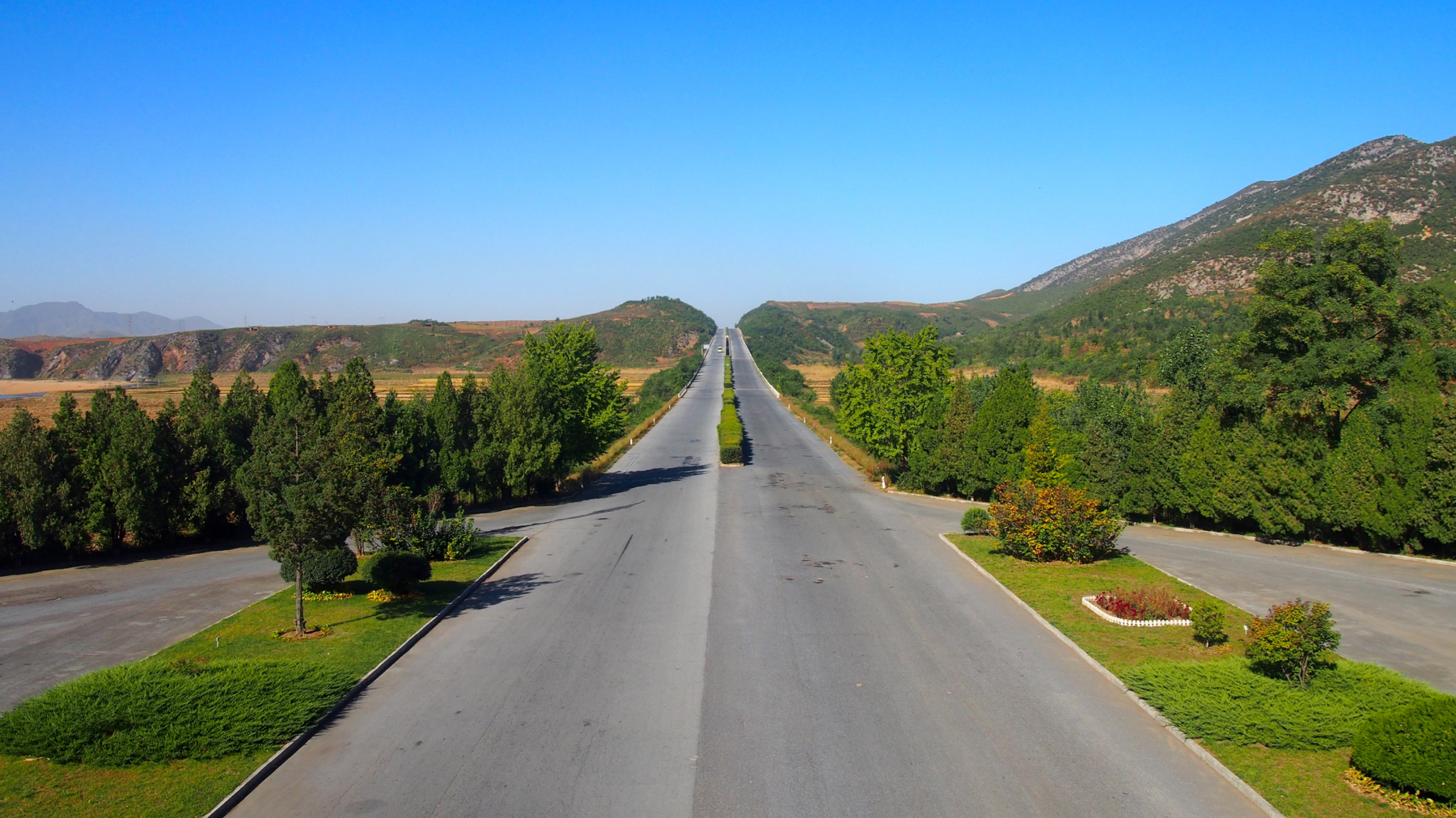 You may recognise this view from a famous VICE Magazine documentary whose crew stopped at a Tea House on the way to the DMZ. This is the view from that tea house. North Korean highways are extremely straight, cutting through mountains and hills as much as possible.