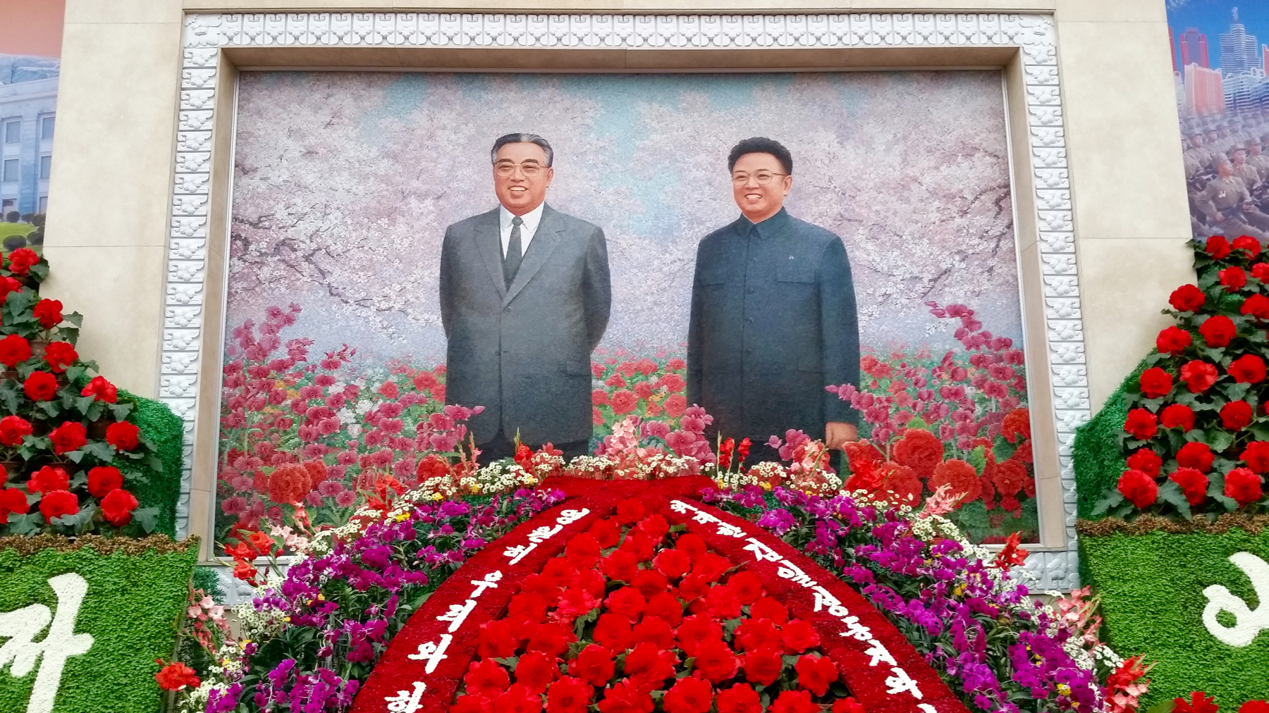 As you enter the exhibit you're greeted by this enormous father-and-son portrait, which I promise you, an image seen time and time again in throughout Pyongyang.
